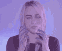 a woman with purple paint on her face is making a face