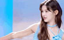 the girl is wearing a blue dress and a blue choker .