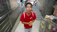 a man wearing a red shirt with a rainbow on it