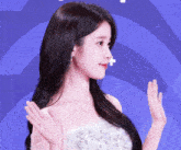 a woman in a white dress is waving her hands