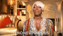 a woman in a colorful dress is standing in a living room and says `` no new friends '' .