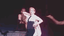 a woman in a white shirt is dancing on a stage