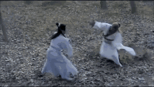 a man and a woman are fighting in a forest .