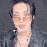 a close up of a person wearing sunglasses and a black leather jacket .