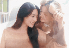 two women are looking at each other and smiling at the camera