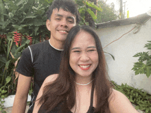 a man and woman are posing for a picture and the woman is smiling