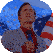 a man in a suit and tie stands in front of a large american flag