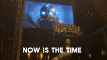 a sign that says " now is the time " with a robot on it