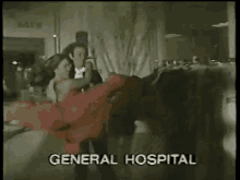 a woman is dancing in front of a general hospital