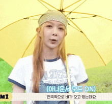 a woman holding a yellow umbrella with a bandana on her head and the word mi on the bottom