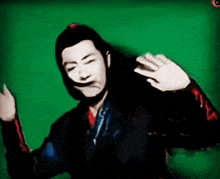a man with long black hair is dancing in front of a green screen