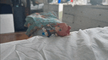 a doll with red hair is laying on a white sheet