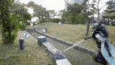 a person is holding a sword in a park surrounded by trees