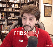 a man wearing a red shirt with the word deux salles on it