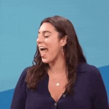 a woman is sticking her tongue out while wearing a blue shirt