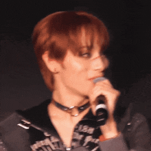 a woman with red hair is holding a microphone