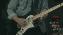 a man playing a guitar in front of a group of people