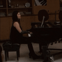 a woman playing a piano in a dark room with a picture of a piano on the wall behind her