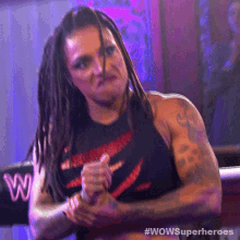 a woman with dreadlocks is wearing a black shirt that says wowsuperheroes