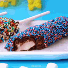 a white plate topped with chocolate covered marshmallows and sprinkles with mr.cakes written on the bottom
