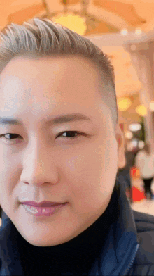 a close up of a man 's face with a turtleneck on