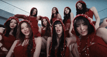 a group of women wearing red hooded outfits pose for a picture