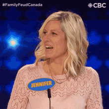 a woman with a name tag that says jennifer stands in front of a microphone