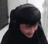 a person is sitting in a chair with a hat on their head and making a funny face .