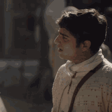 a man in a white sweater is talking to a statue of a man