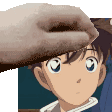 a close up of a person 's hand touching a boy 's head .
