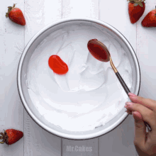 a bowl of whipped cream with a spoon in it that says mr.cakes on it