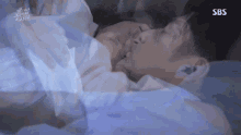 a man and a woman are laying in bed .