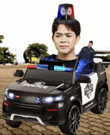 a boy is sitting in a police car with a man on top of it