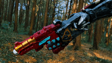 a person is holding a toy gun in a forest with a glove on