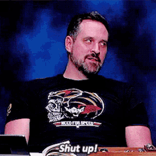 a man wearing a t-shirt that says ' shut up ' on it
