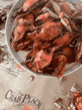 a plate of crabs sits on a table with a sign that says " the crab place "