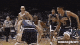 a group of basketball players are playing a game of basketball .