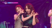 a girl in a green shirt is dancing on stage