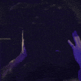 a man with green hair holds his hand to his head in a dark room