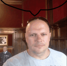 a bald man wearing sunglasses stands in front of a red wall with a speech bubble above his head