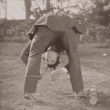 a black and white photo of a man playing with a rope