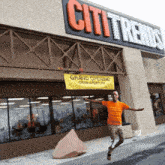 a man is jumping in front of a store called citi trends