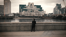 a woman leaning against a railing in front of a large building