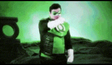 a man in a green lantern costume is standing in front of a green background .