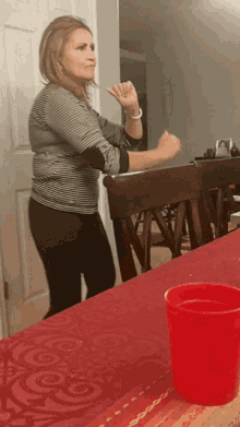 a woman sitting at a table with a red cup