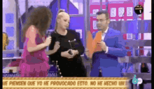a woman in a pink dress is talking to a man in a blue suit on a television show