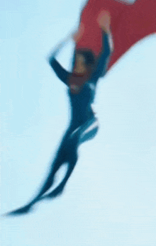 a woman in a wetsuit is holding a red surfboard on her head .