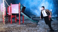 a man in a suit and tie is running towards a slide