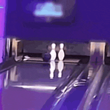 a bowling alley with a purple background and two bowling pins