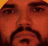 a close up of a man 's face with a beard wearing a yellow hat